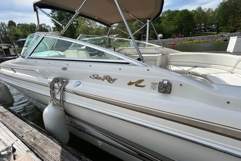 Slide: The Image of 1998 Sea Ray 280 Bow Rider boat docked, featuring white exterior and spacious seating. - 15