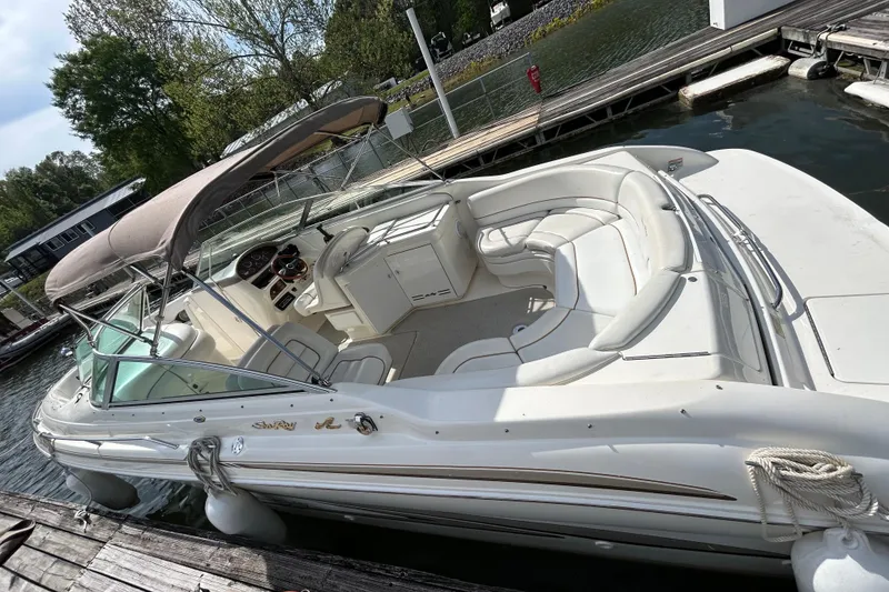 Slide: The Image of 1998 Sea Ray 280 Bow Rider boat docked, featuring spacious seating and canopy. - 16