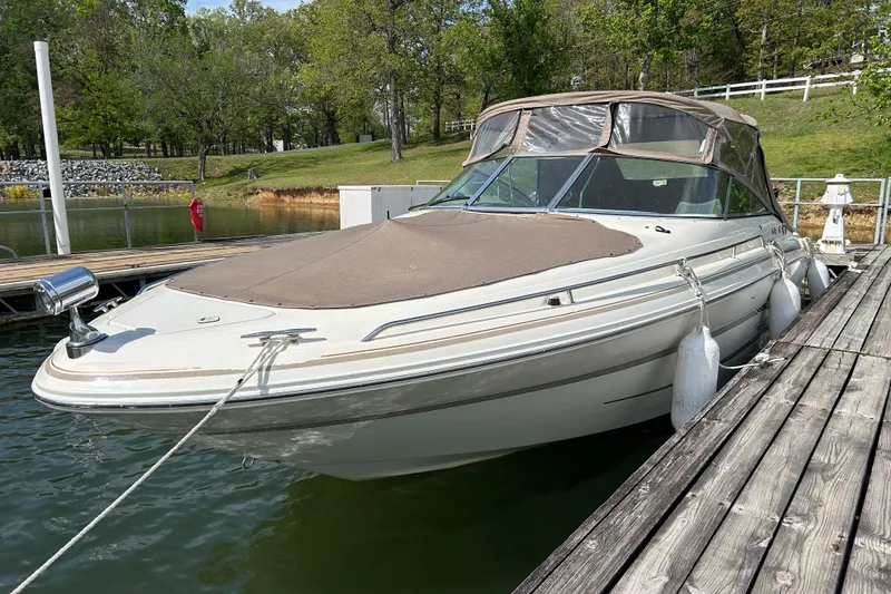 Slide: The Image of 1998 Sea Ray 280 Bow Rider docked at a serene lakeside marina. - 31