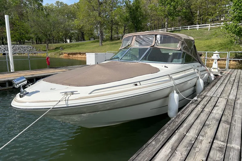 Slide: The Image of 1998 Sea Ray 280 Bow Rider docked at a serene lakeside marina. - 37