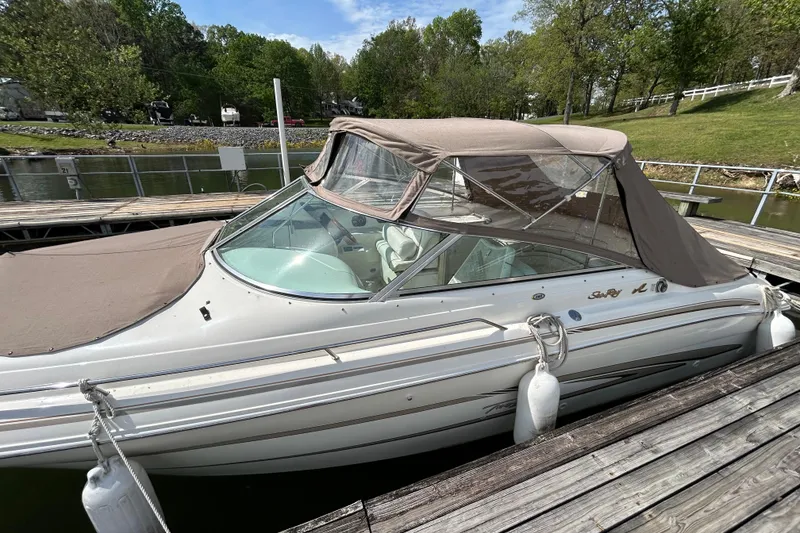 Slide: The Image of 1998 Sea Ray 280 Bow Rider docked with canopy, surrounded by lush greenery. - 38