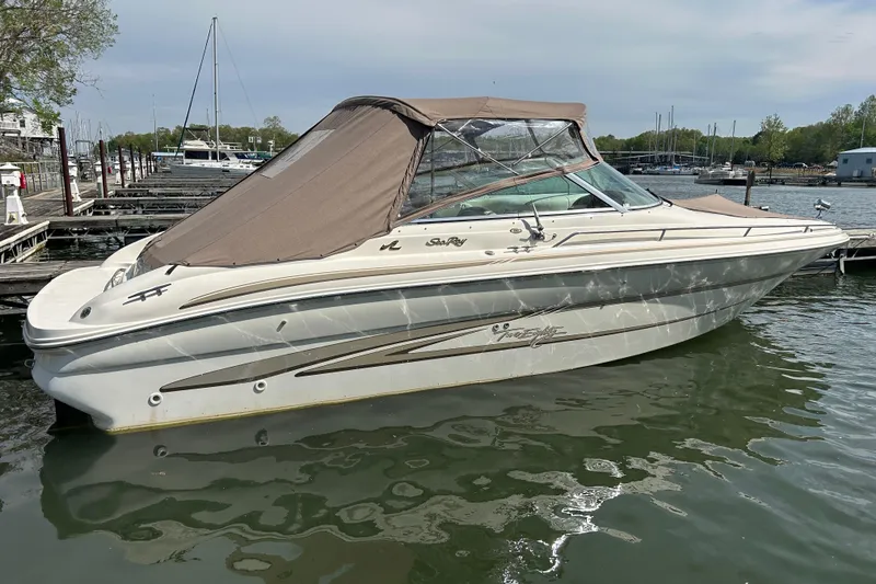 Slide: The Image of 1998 Sea Ray 280 Bow Rider boat docked in a marina, featuring a brown canopy. - 39