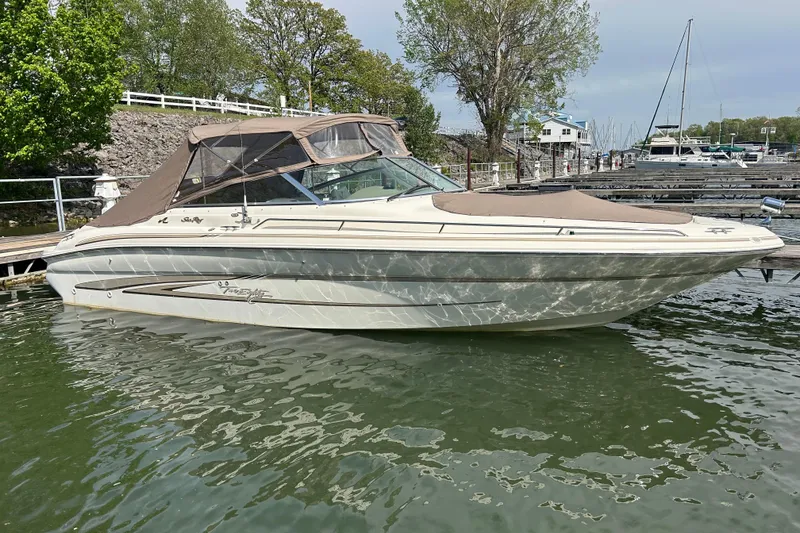 Slide: The Image of 1998 Sea Ray 280 Bow Rider boat docked in a marina, surrounded by water and trees. - 41