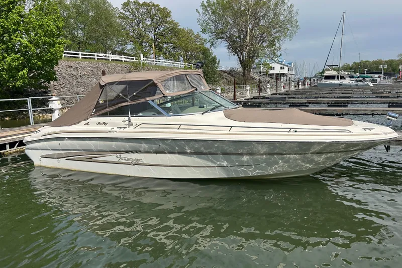 Slide: The Image of 1998 Sea Ray 280 Bow Rider boat docked in a marina, surrounded by trees and water. - 56