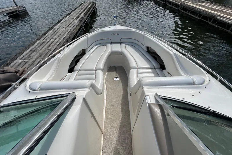 Slide: The Image of 1998 Sea Ray 280 Bow Rider boat interior with white seating and dockside view. - 58