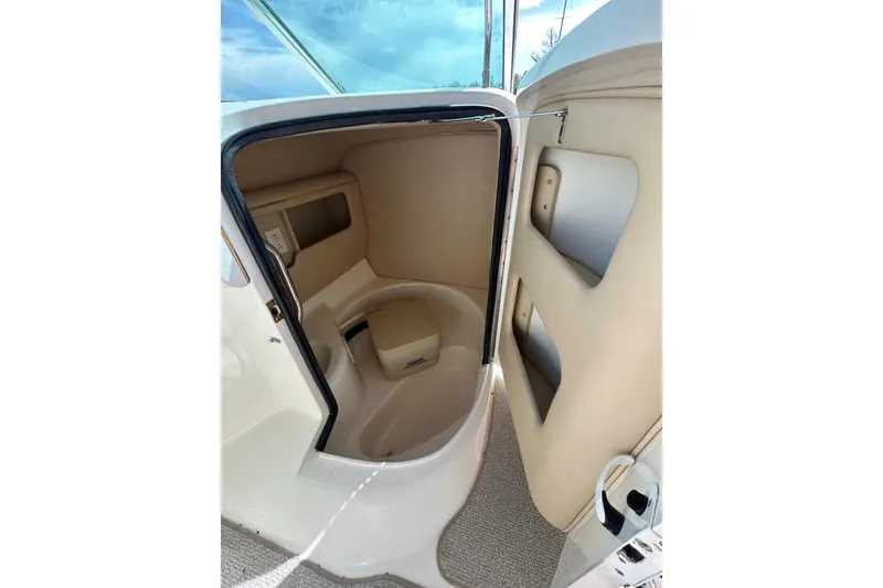 Slide: The Image of 1998 Sea Ray 280 Bow Rider interior cabin with beige seating and storage compartments. - 59