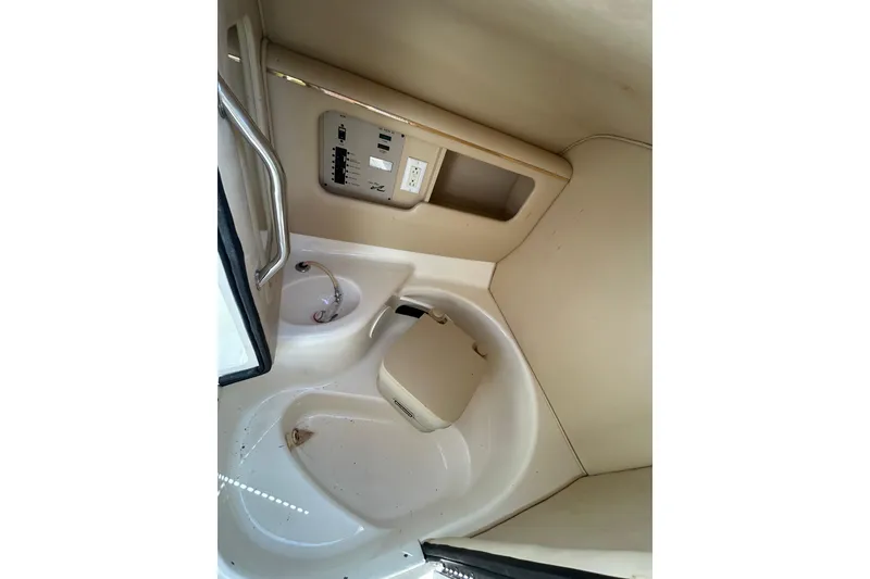 Slide: The Image of Interior of a 1998 Sea Ray 280 Bow Rider boat, featuring a compact bathroom area. - 61