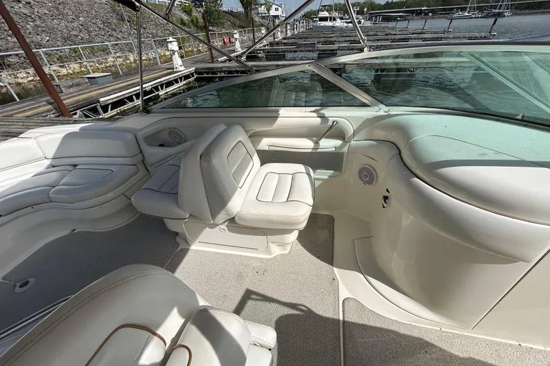 Slide: The Image of 1998 Sea Ray 280 Bow Rider interior with white seating and waterfront view. - 62