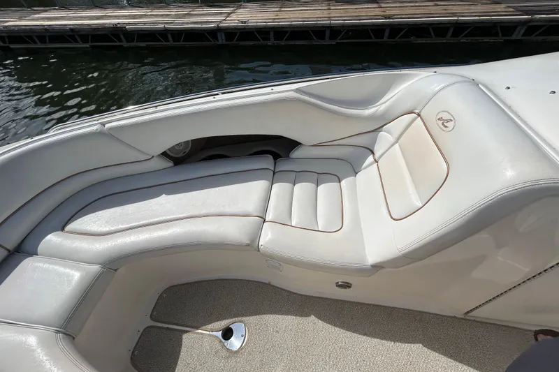 Slide: The Image of Interior seating of a 1998 Sea Ray 280 Bow Rider boat, featuring white cushioned seats. - 64