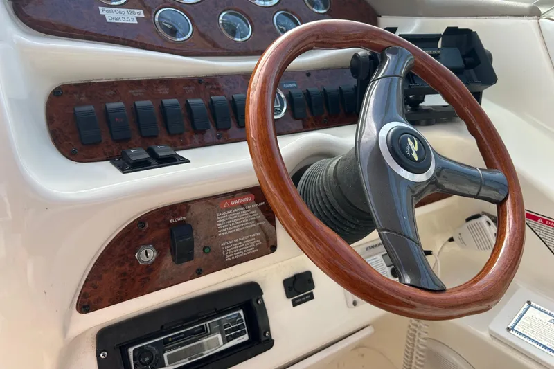 Slide: The Image of 1998 Sea Ray 280 Bow Rider dashboard with wooden steering wheel and control panel. - 73