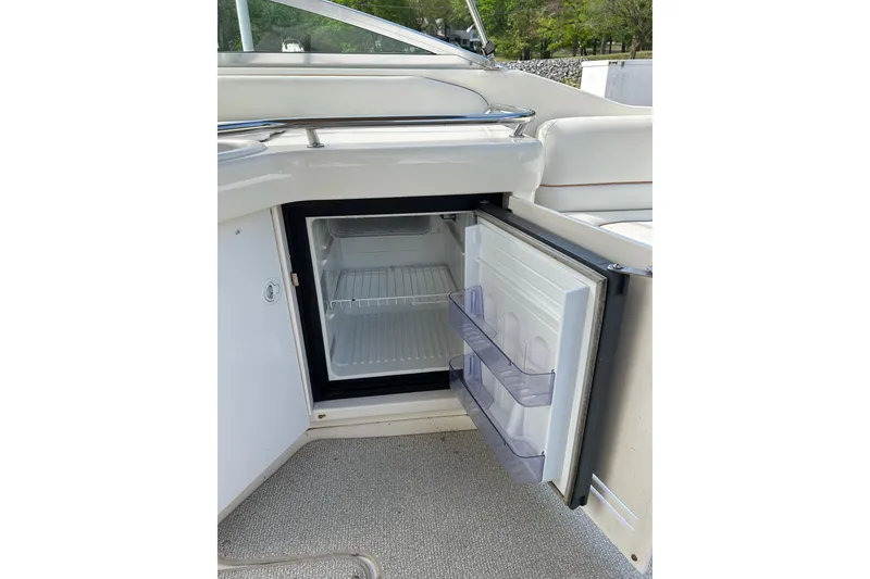 Slide: The Image of Open mini fridge on 1998 Sea Ray 280 Bow Rider boat, showcasing interior shelves. - 76