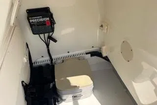 Slide: The Image of 2008 Boston Whaler 230 Dauntless interior with Precision charger and storage compartment. - 10