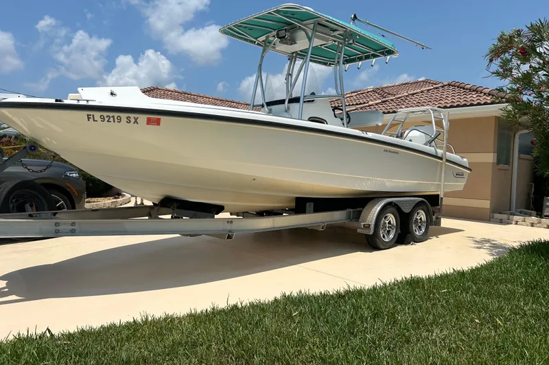 Slide: The Image of 2008 Boston Whaler 230 Dauntless boat on trailer, parked in driveway under blue sky. - 20
