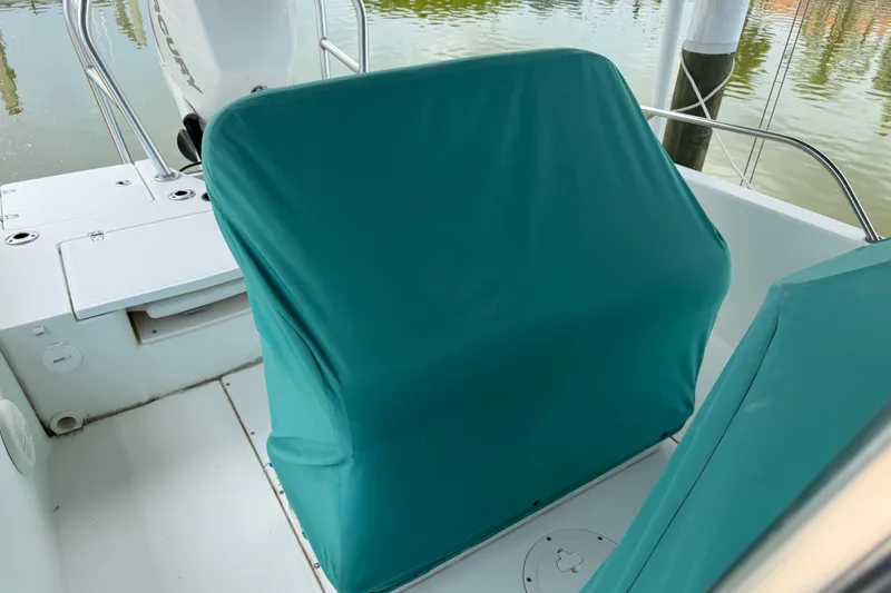 Slide: The Image of Boston Whaler 230 Dauntless 2008 boat interior with teal seat covers and Mercury engine. - 25