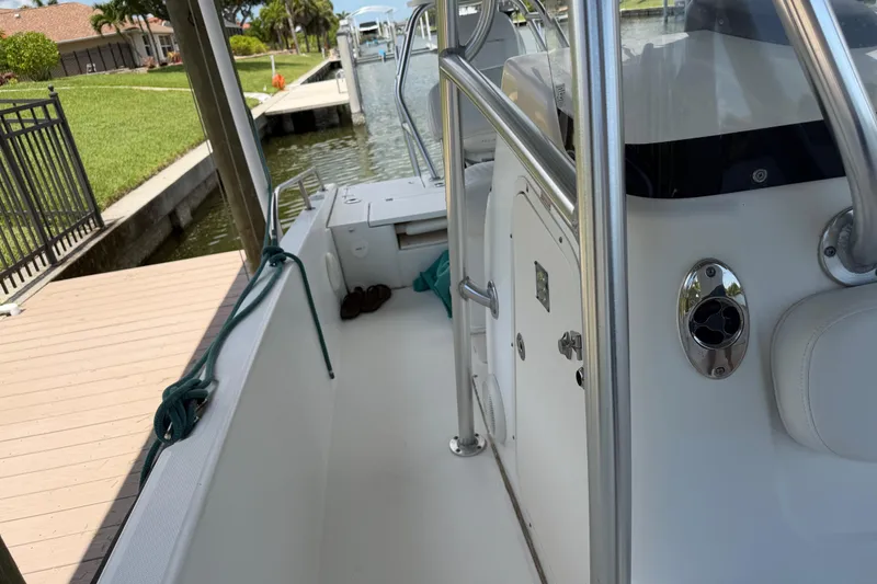 Slide: The Image of 2008 Boston Whaler 230 Dauntless boat docked, showcasing interior and railing details. - 36
