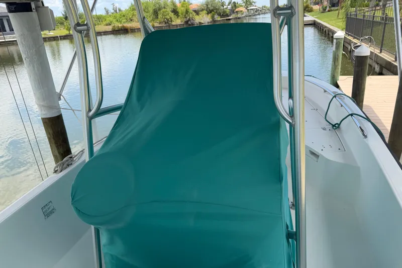 Slide: The Image of Boston Whaler 230 Dauntless 2008 boat with teal cover docked by a canal. - 26