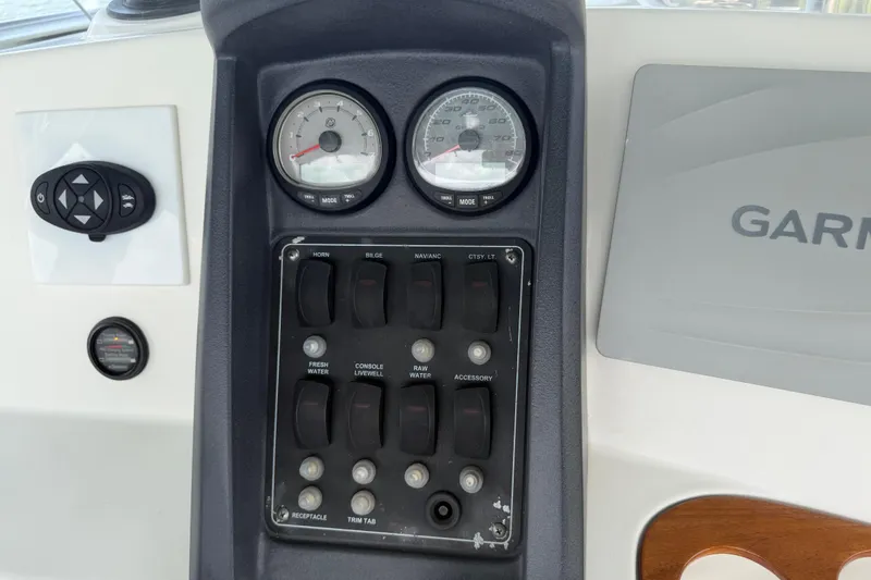 Slide: The Image of Control panel of a 2008 Boston Whaler 230 Dauntless boat with gauges and switches. - 30