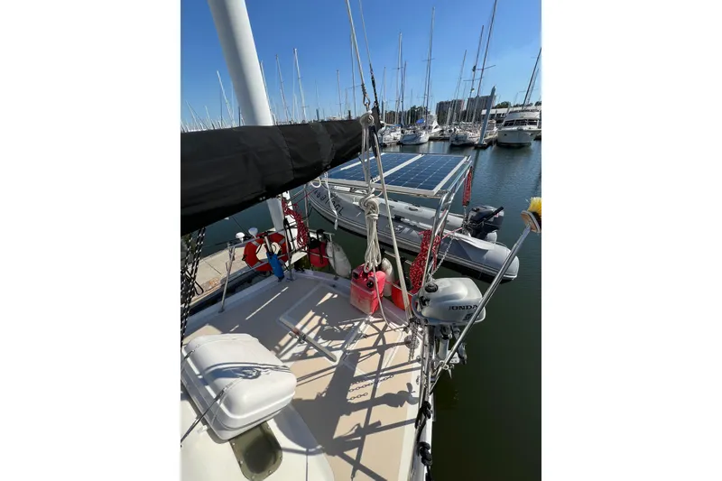 Slide: The Image of 1978 Gulfstar Ketch sailboat docked in marina with solar panels and outboard motor. - 10