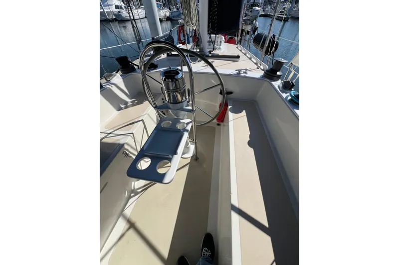 Slide: The Image of 1978 Gulfstar Ketch cockpit with steering wheel and cup holders, docked at marina. - 13