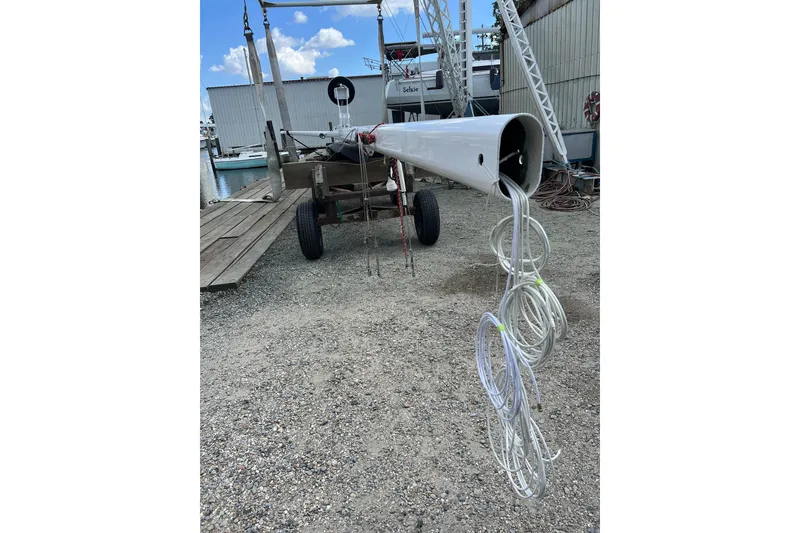 Slide: The Image of 1978 Gulfstar Ketch mast on trailer, with coiled ropes, in a boatyard setting. - 15