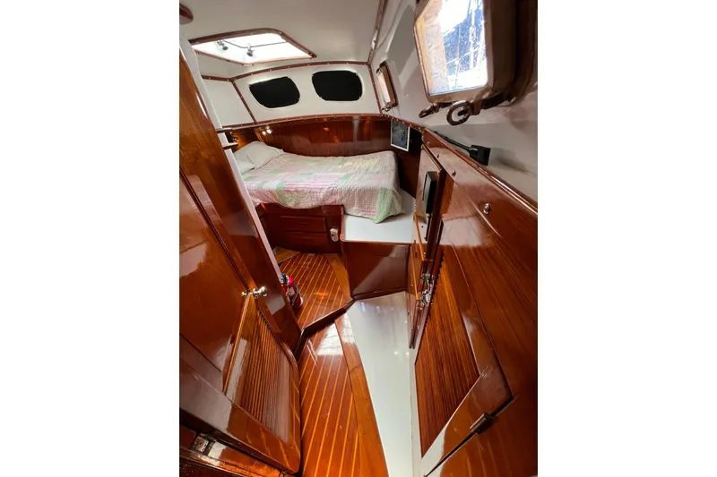 Slide: The Image of 1978 Gulfstar Ketch cabin interior with polished wood and cozy bed. - 25