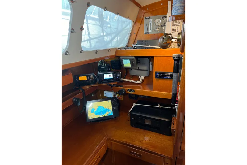 Slide: The Image of Navigation equipment inside a 1978 Gulfstar Ketch sailboat, featuring modern electronics and wooden interior. - 28