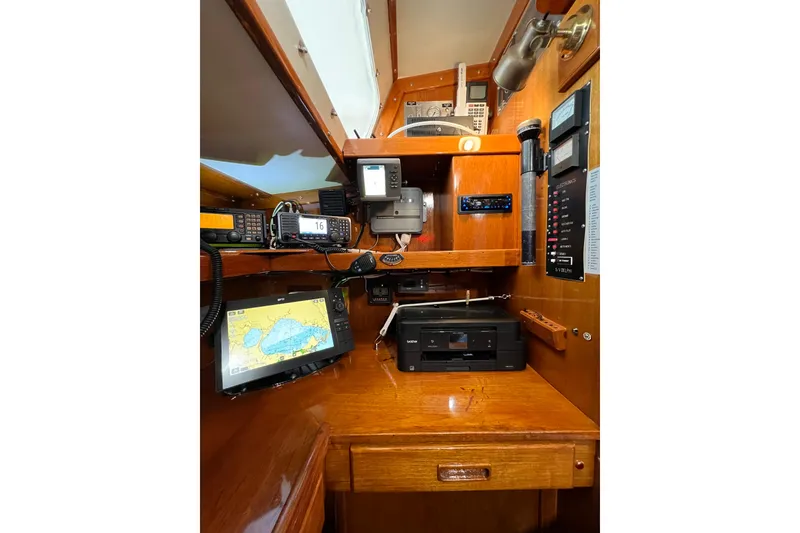 Slide: The Image of Navigation equipment inside a 1978 Gulfstar Ketch sailboat cabin, featuring a chart plotter and communication devices. - 30