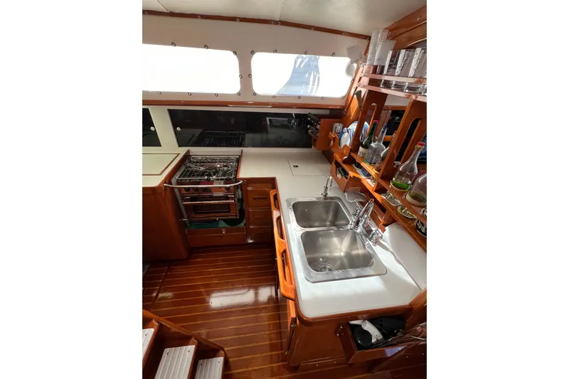 Slide: The Image of 1978 Gulfstar Ketch interior kitchen with dual sinks, stove, and wooden cabinetry. - 32