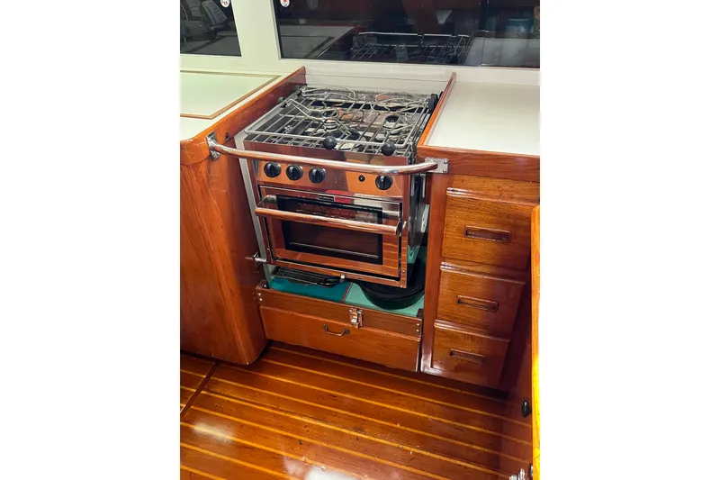 Slide: The Image of 1978 Gulfstar Ketch kitchen with stove, wooden cabinetry, and polished flooring. - 33