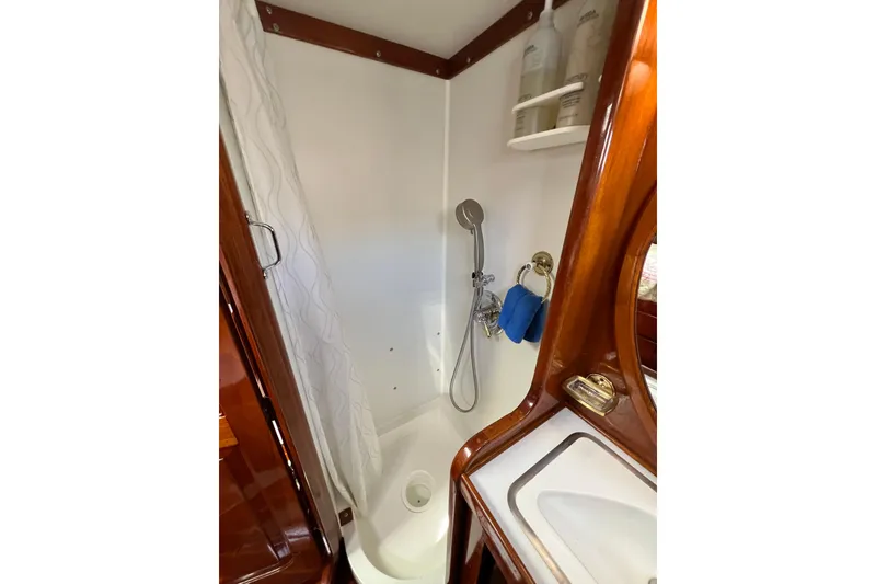 Slide: The Image of 1978 Gulfstar Ketch bathroom with shower, wooden accents, and storage shelves. - 41