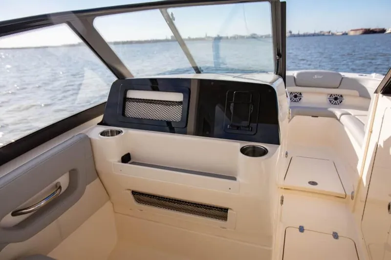 Slide: The Image of Manufacturer Provided Image: 2025 Scout 277 Dorado boat interior with dashboard and seating, on calm water. - 9