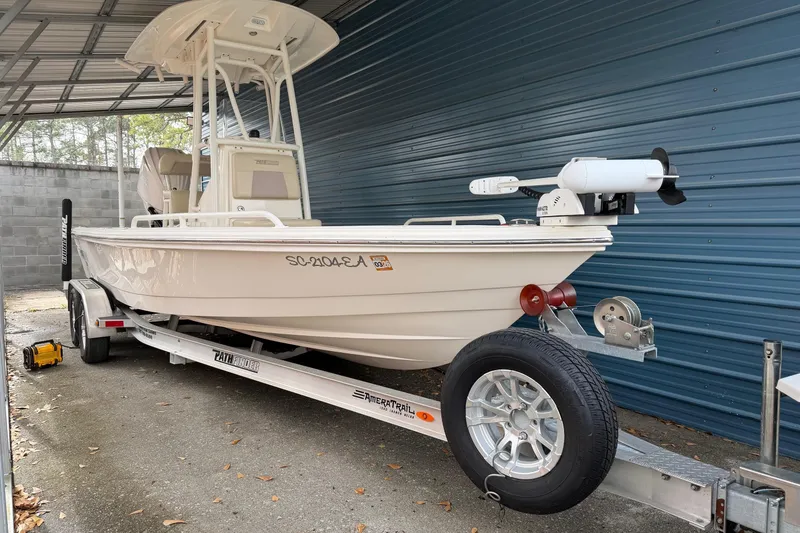 Slide: The Image of 2022 Pathfinder 2200 TRS boat on trailer, parked under a metal shelter. - 11