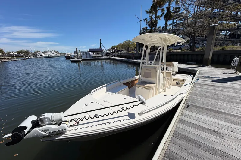 Slide: The Image of 2022 Pathfinder 2200 TRS boat docked at a marina under clear blue skies. - 13
