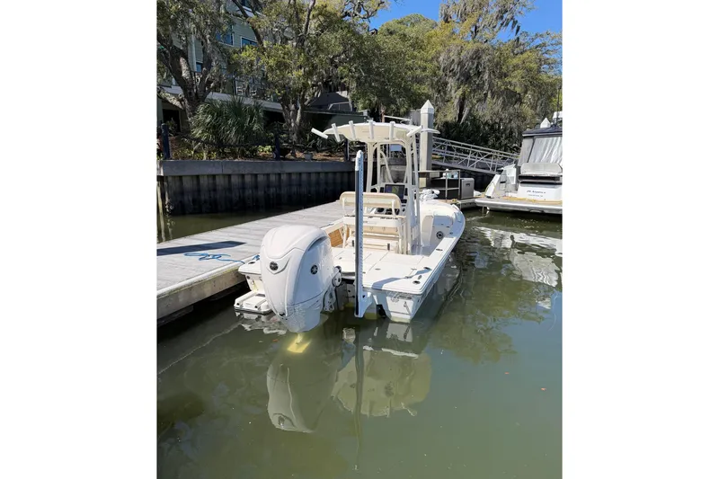 Slide: The Image of 2022 Pathfinder 2200 TRS boat docked in a serene marina setting. - 15
