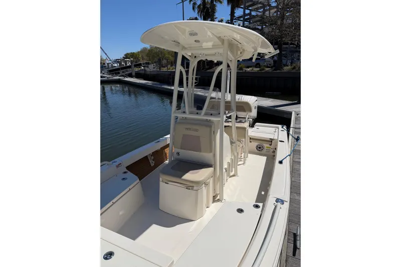 Slide: The Image of 2022 Pathfinder 2200 TRS boat docked, featuring a center console and seating area. - 16