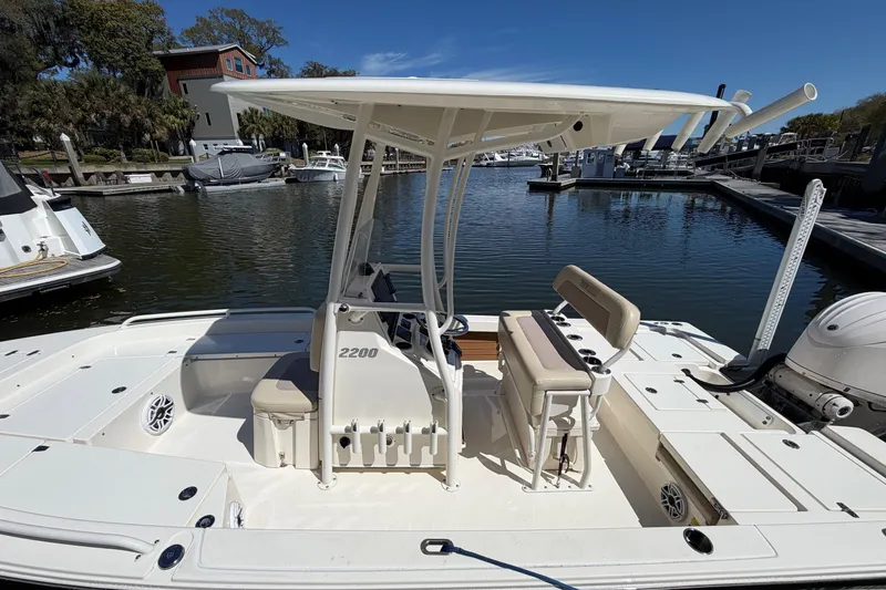 Slide: The Image of 2022 Pathfinder 2200 TRS boat docked at a marina under clear blue skies. - 17
