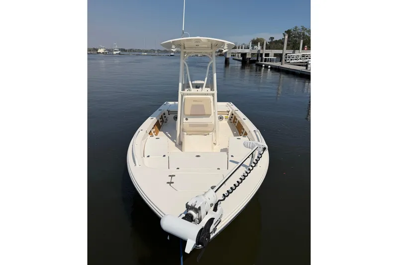 Slide: The Image of 2022 Pathfinder 2200 TRS boat docked on calm water, featuring a sleek design. - 2