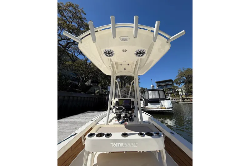 Slide: The Image of 2022 Pathfinder 2200 TRS boat console with T-top and electronics, docked by waterfront homes. - 23