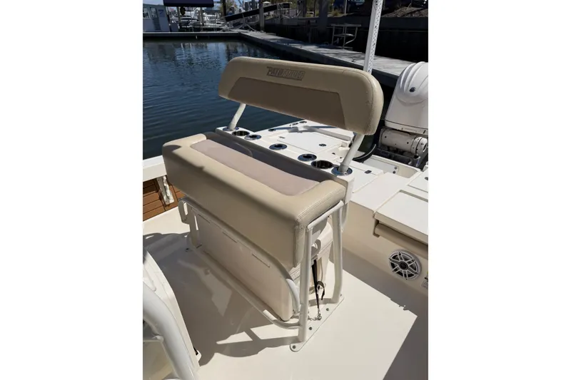 Slide: The Image of 2022 Pathfinder 2200 TRS boat seat with beige upholstery, docked by the water. - 24