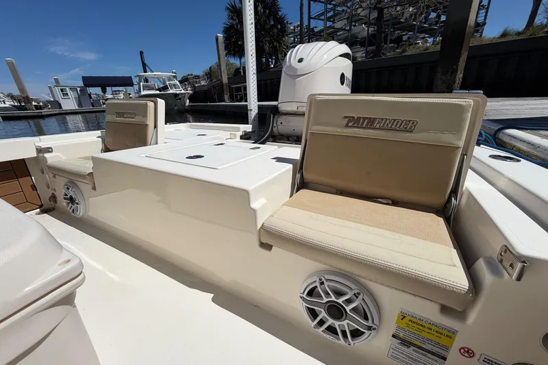 Slide: The Image of 2022 Pathfinder 2200 TRS boat interior with seating and speaker, docked at marina. - 29