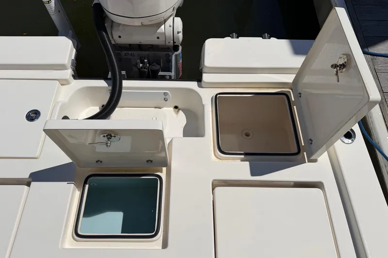 Slide: The Image of 2022 Pathfinder 2200 TRS boat deck with open storage compartments and motor. - 30