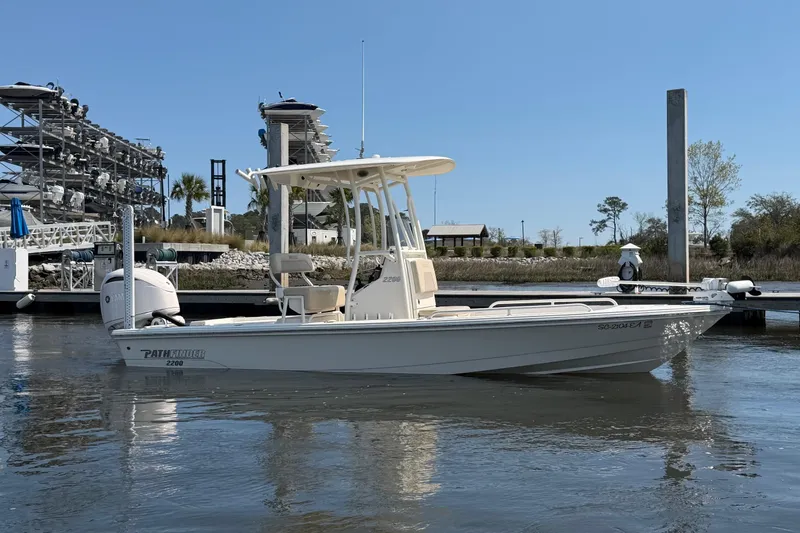Slide: The Image of 2022 Pathfinder 2200 TRS boat docked in a marina under clear blue sky. - 4