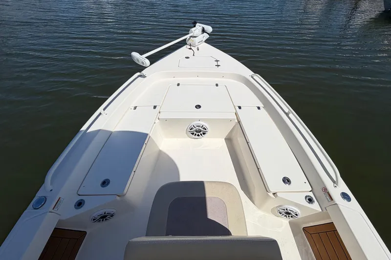Slide: The Image of 2022 Pathfinder 2200 TRS boat deck with storage compartments and speakers on calm water. - 5