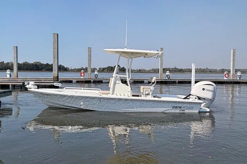 Slide: The Image of 2022 Pathfinder 2200 TRS boat docked on calm water with Yamaha engine. - 6