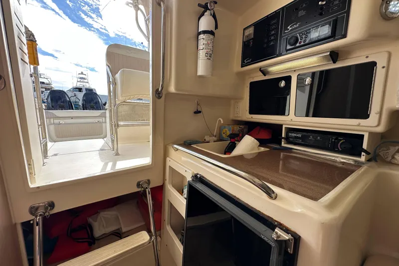 Slide: The Image of Interior view of 2001 Scout 280 Abaco boat, featuring a compact kitchenette and control panel. - 12