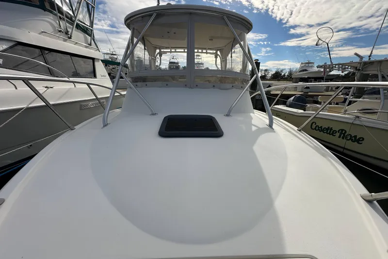 Slide: The Image of 2001 Scout 280 Abaco boat docked, featuring a sleek white deck and cabin enclosure. - 17