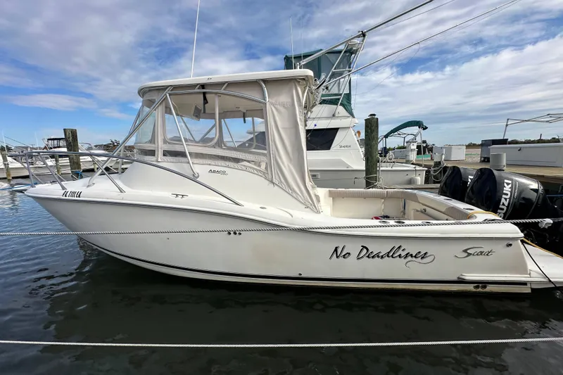 Slide: The Image of 2001 Scout 280 Abaco boat docked, featuring "No Deadlines" text on the side. - 2