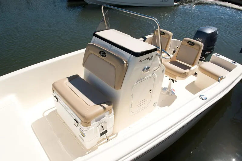Slide: The Image of Manufacturer Provided Image: 2025 Scout 175 Sportfish boat with beige seating, docked on calm water. - 5