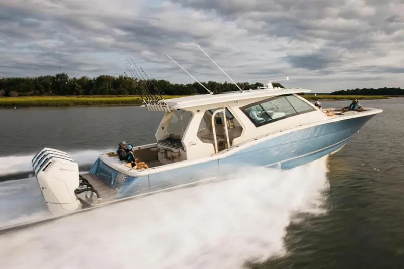 Slide: The Image of Manufacturer Provided Image: 2025 Scout 530 LXF boat cruising on a lake under cloudy skies. - 2