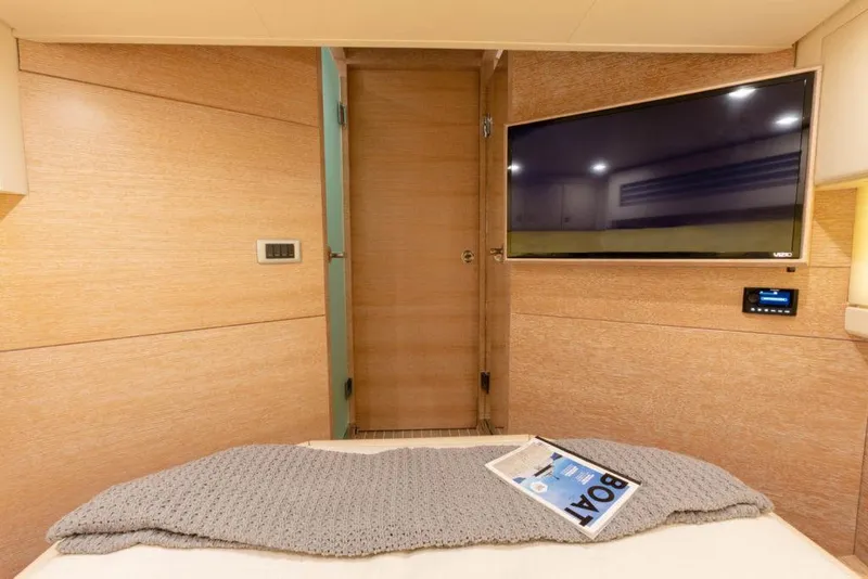Slide: The Image of Manufacturer Provided Image: Luxurious interior of 2025 Scout 530 LXF yacht with TV and cozy bedding. - 25